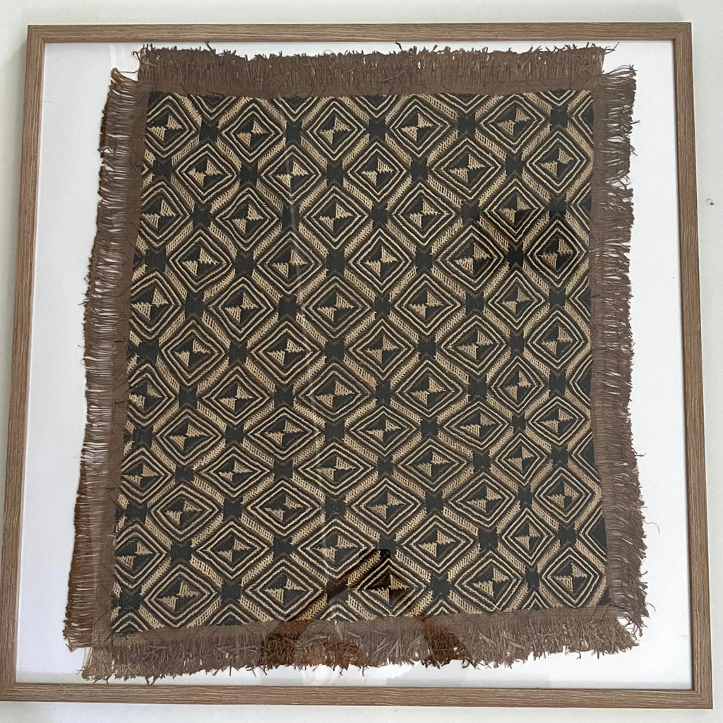 Framed woven textile with geometric pattern on a white background