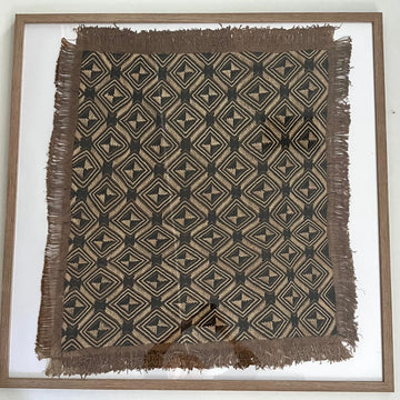 Framed woven textile with geometric pattern on a white background